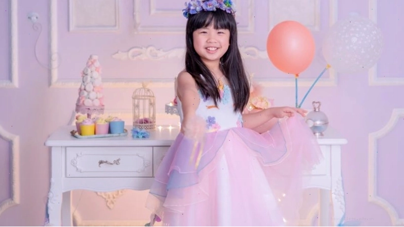 Bé gái 7 tuổi vui vẻ trong bữa tiệc sinh nhật với bánh kem và bóng bay