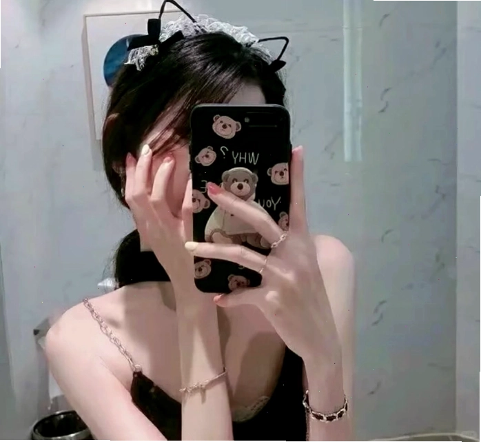 Cô gái che mặt bằng điện thoại khi nhìn vào gương