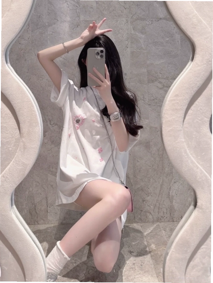 Cô gái xinh che mặt bằng điện thoại trước gương