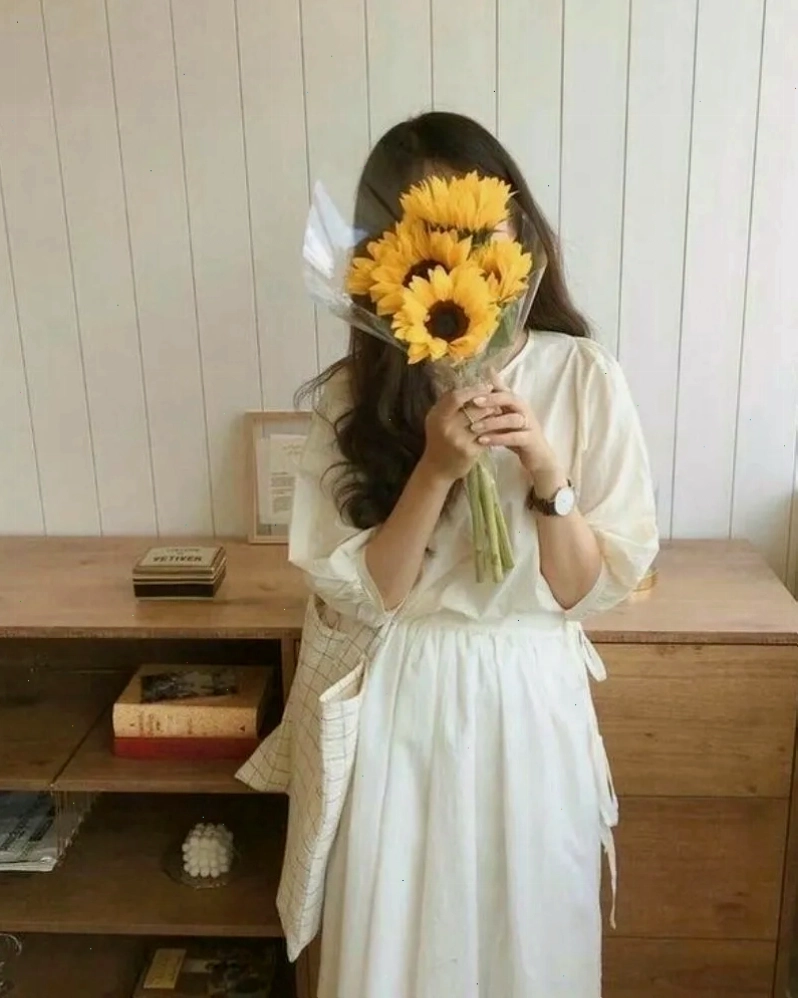 Cô gái xinh che mặt bằng hoa hướng dương, mang năng lượng tích cực